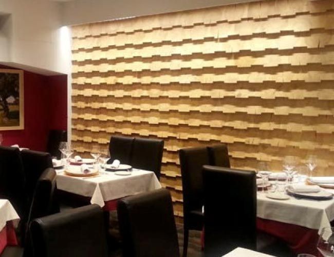 Un restaurante con mesas y sillas y una pared de madera.