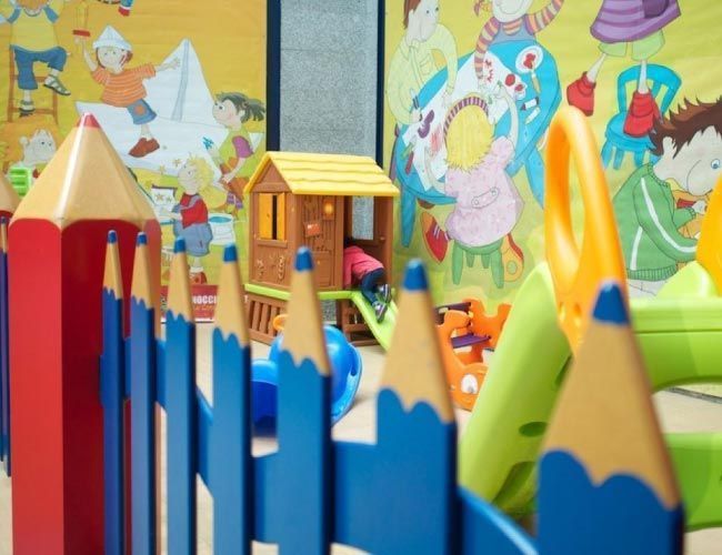 Un parque infantil con una valla que parece lápices.