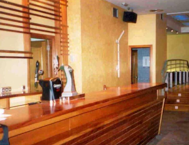 Una gran barra de madera en una habitación con paredes amarillas.