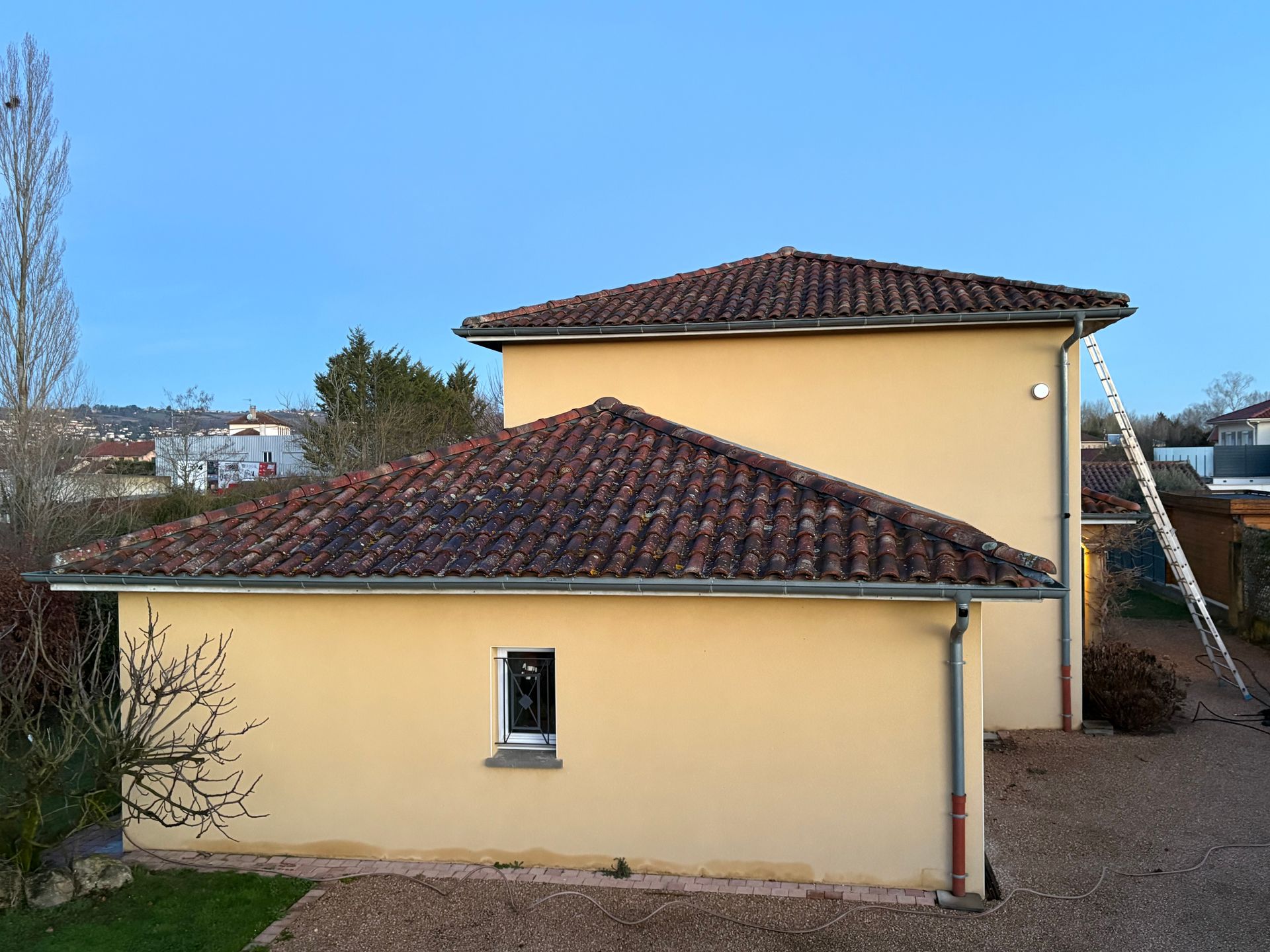 Maison à façade jaune avec toiture sale