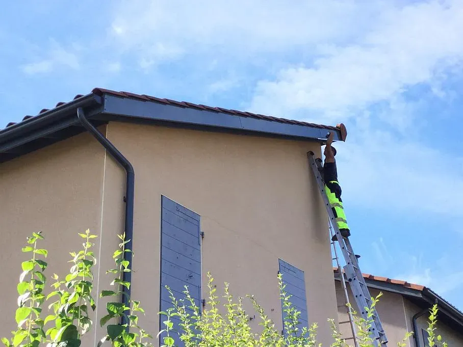 Artisan installant une planche de rive