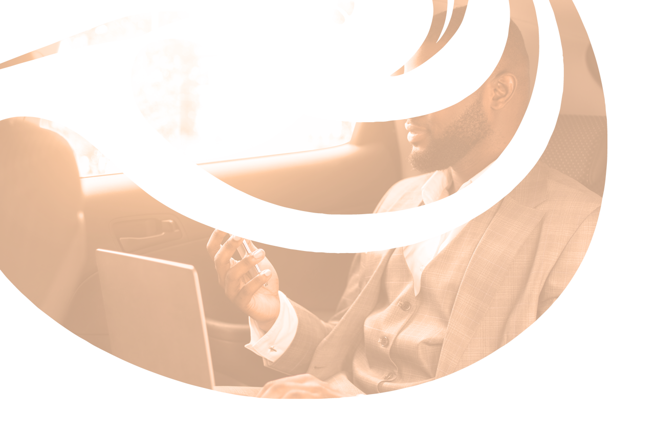 Homme en costume avec un ordinateur sur les genoux dans une voiture.