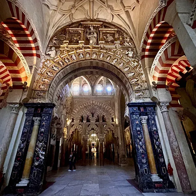 El interior de un edificio con columnas y arcos.