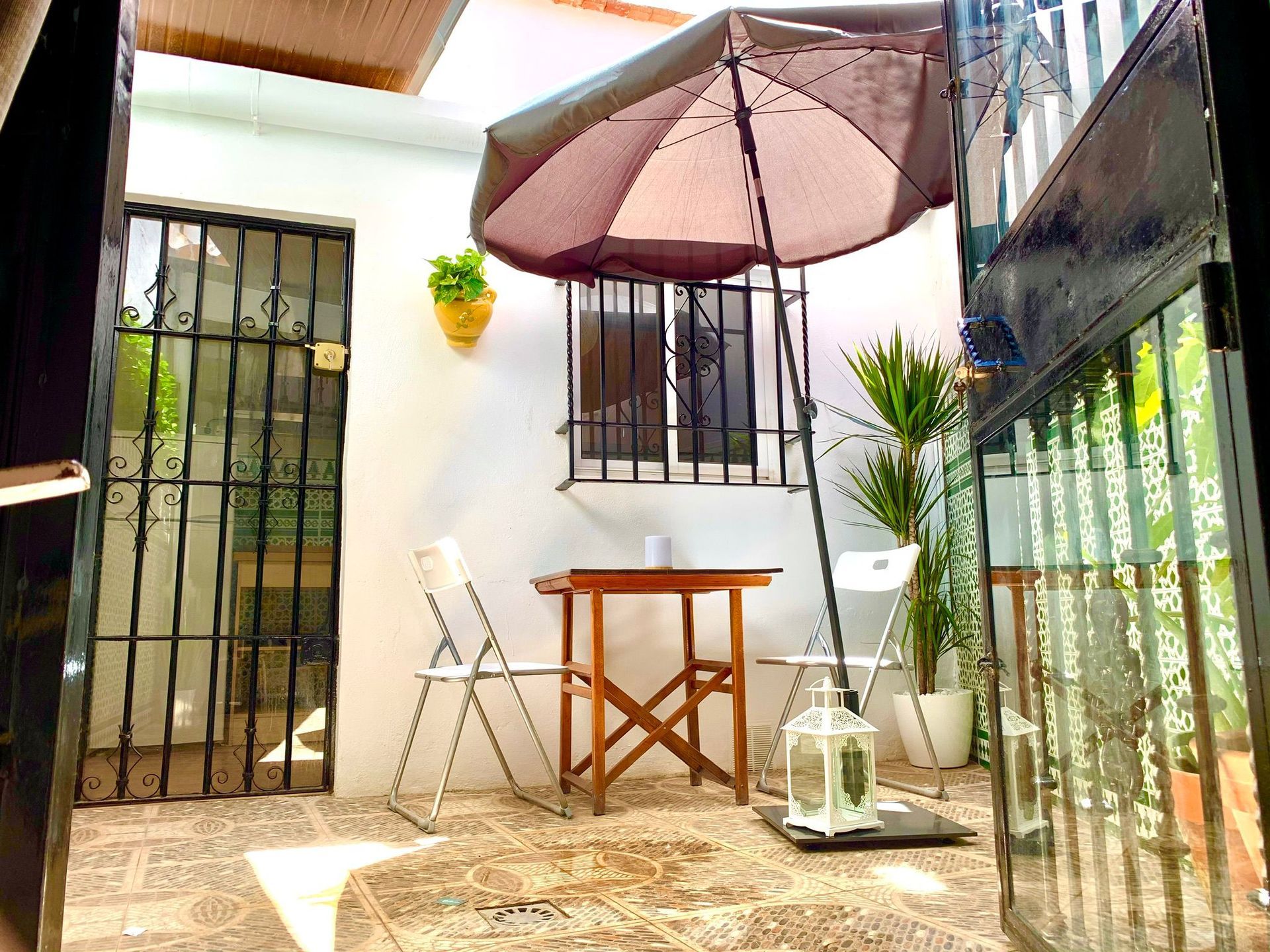 Un patio con una mesa y sillas y una sombrilla.