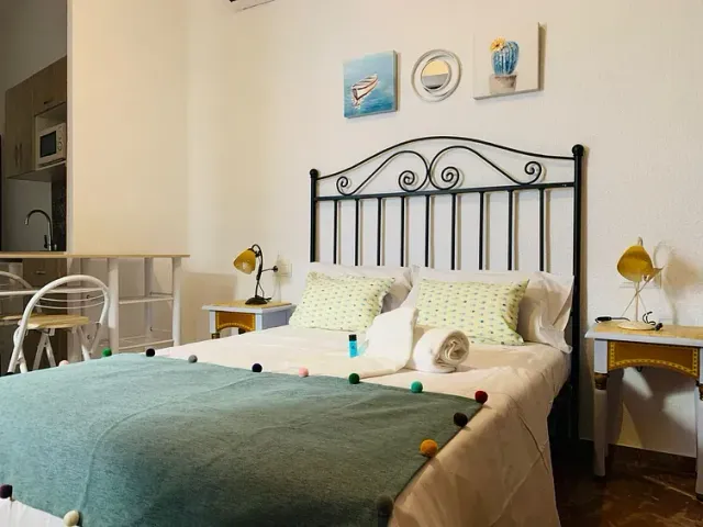 Un dormitorio con una cama, dos mesitas de noche y una mesa.