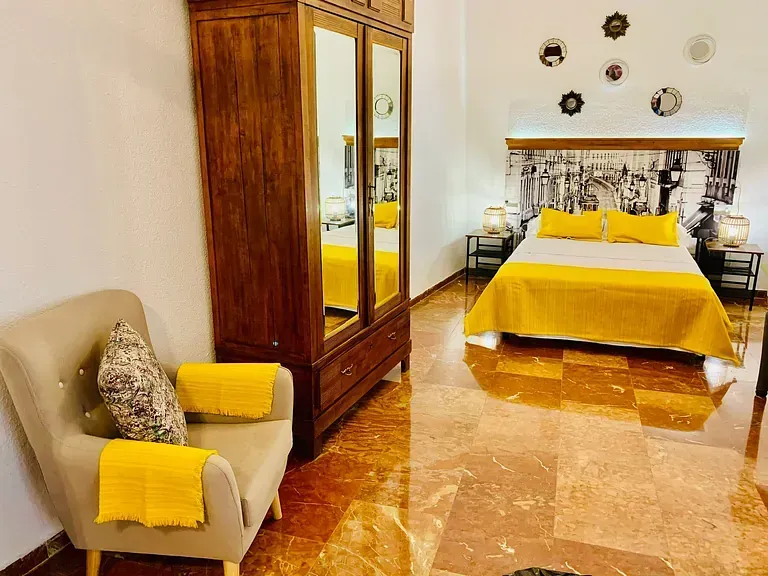 Un dormitorio con una cama, una silla y un armario.