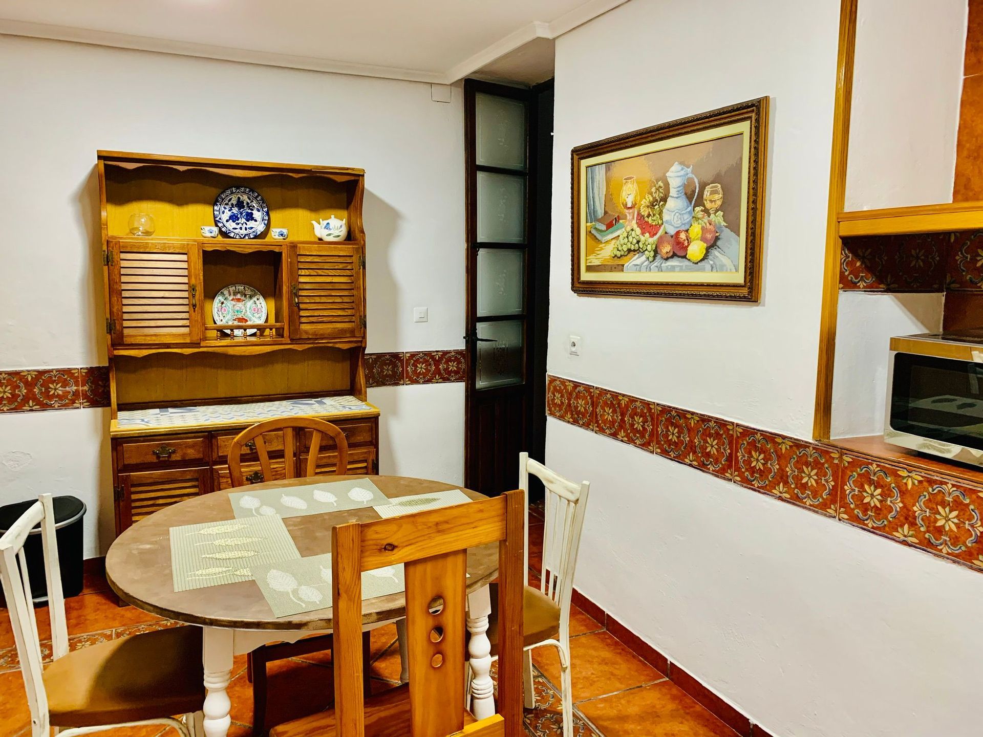 Un comedor con una mesa y sillas y un cuadro en la pared.
