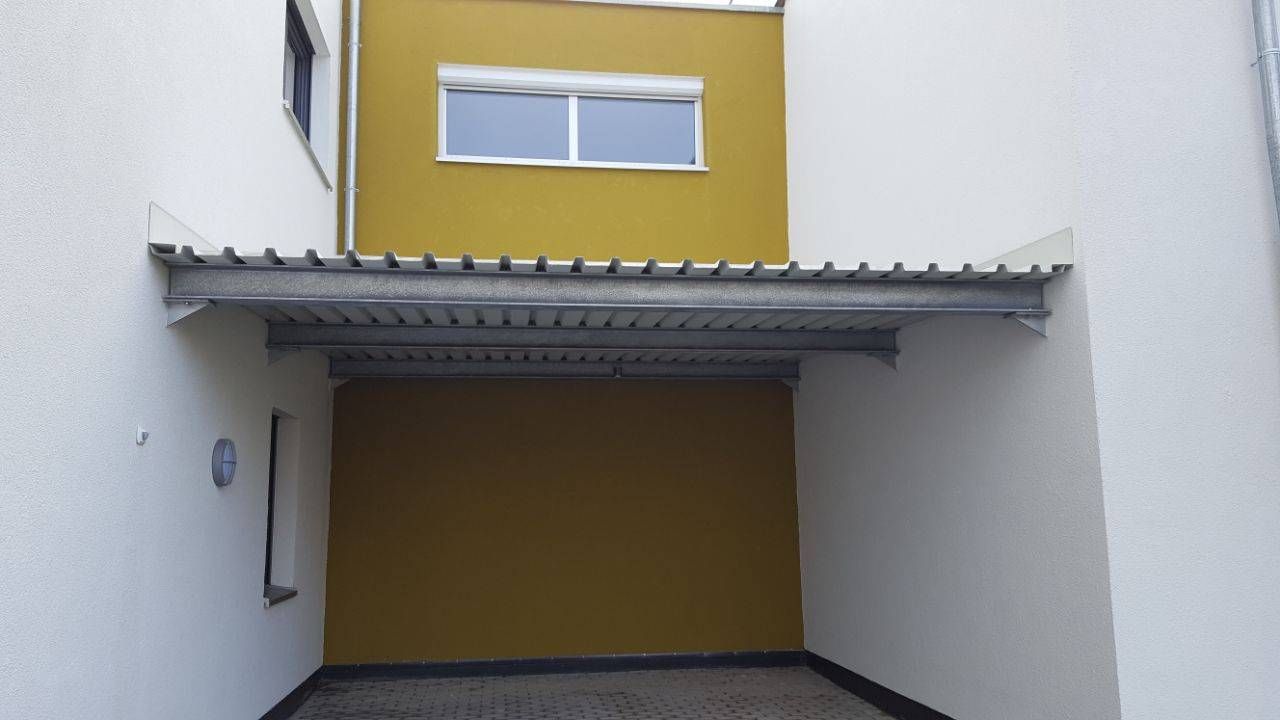 ein weißes Gebäude mit einer gelben Wand und einem Metalldach