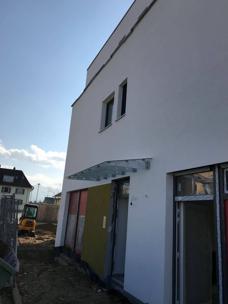 ein weißes Gebäude mit einem Glasdach über der Tür