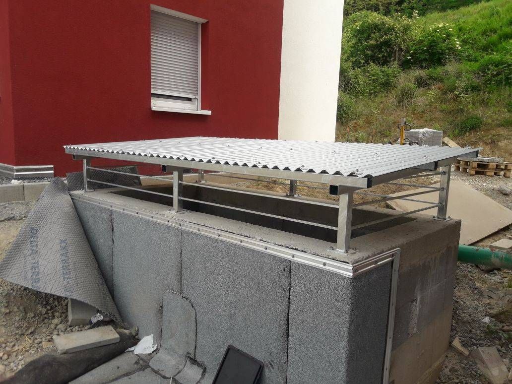 ein rotes Gebäude mit einem Metalldach und einem Fenster