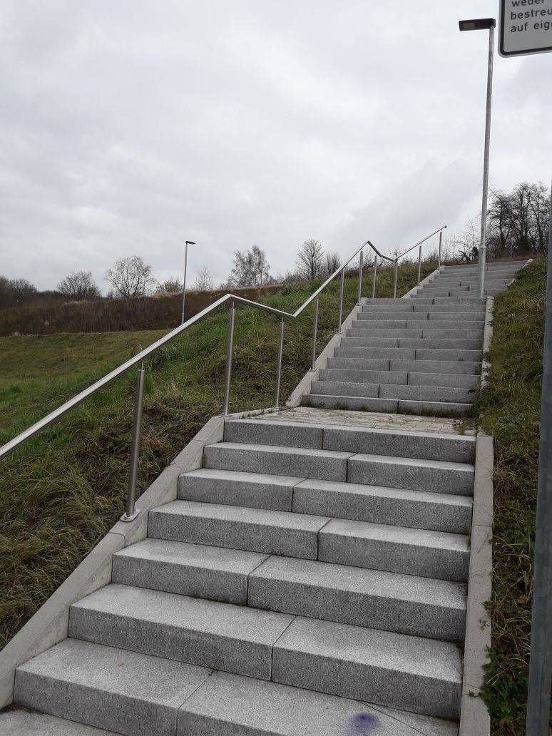 eine Treppe, die zu einem grasbewachsenen Hügel hinaufführt
