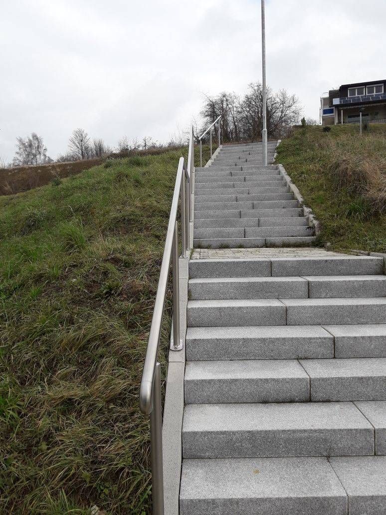 eine Treppe, die zu einem grasbewachsenen Hügel hinaufführt.