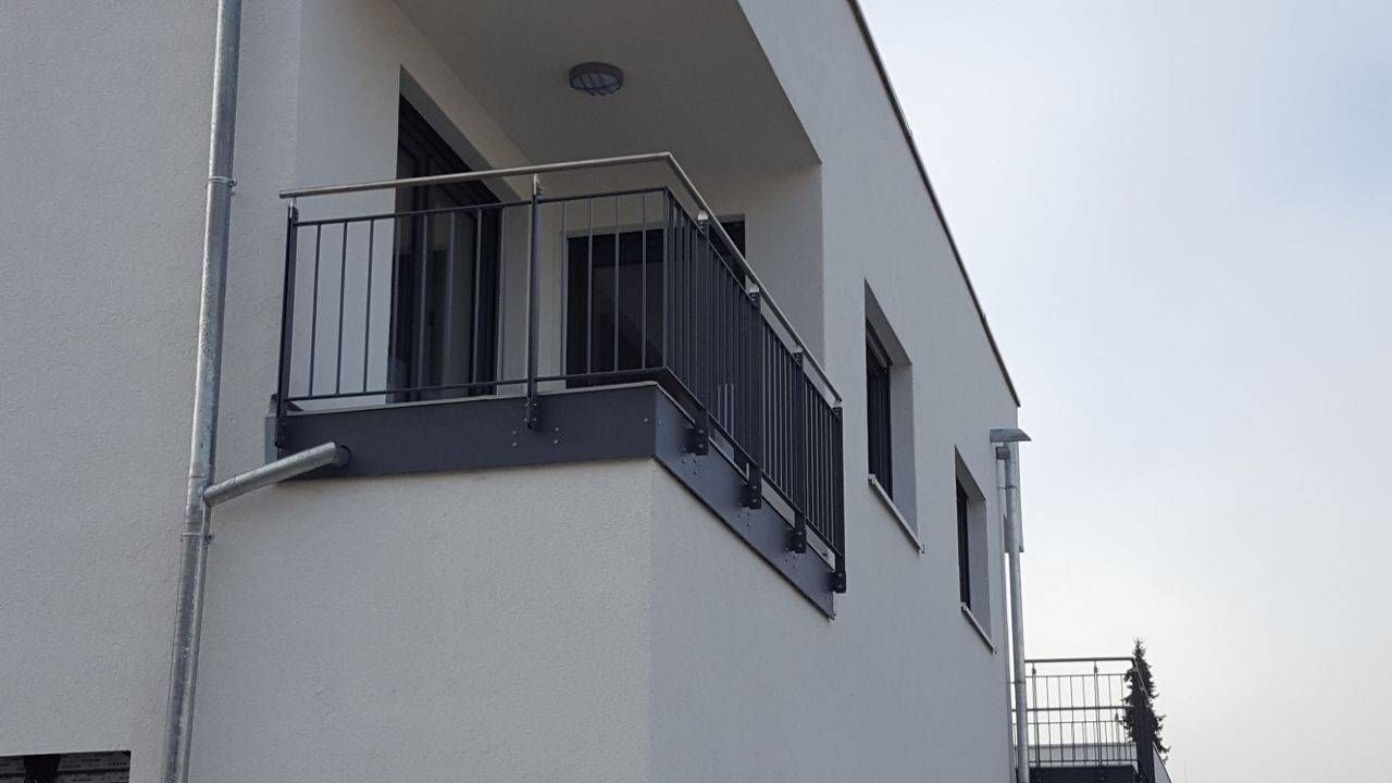 ein Balkon an der Seite eines Gebäudes, zu dem eine Treppe hinaufführt.