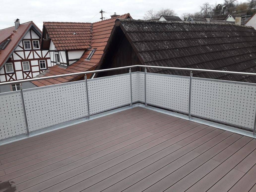 ein Balkon mit Metallgeländer und Holzboden