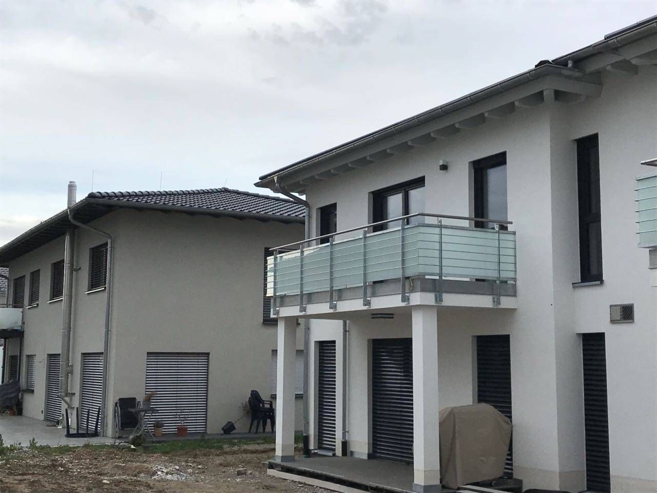 ein weißes Gebäude mit einem Balkon an der Seite.