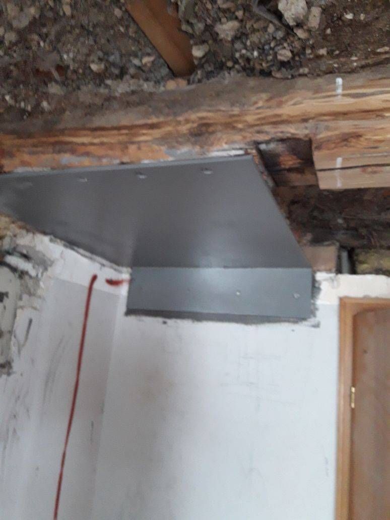 Ein Stück Metall hängt von der Decke eines Raumes.