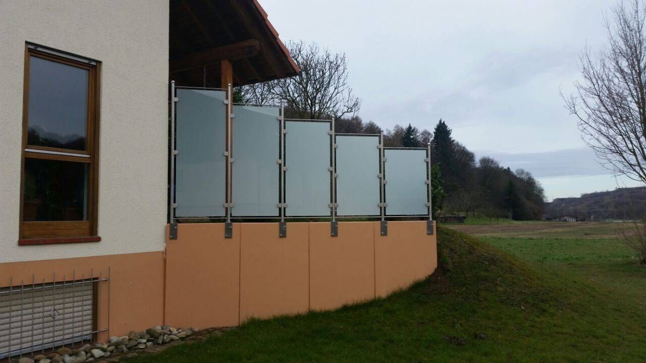 ein Haus mit einem Zaun und einem Fenster an der Seite.