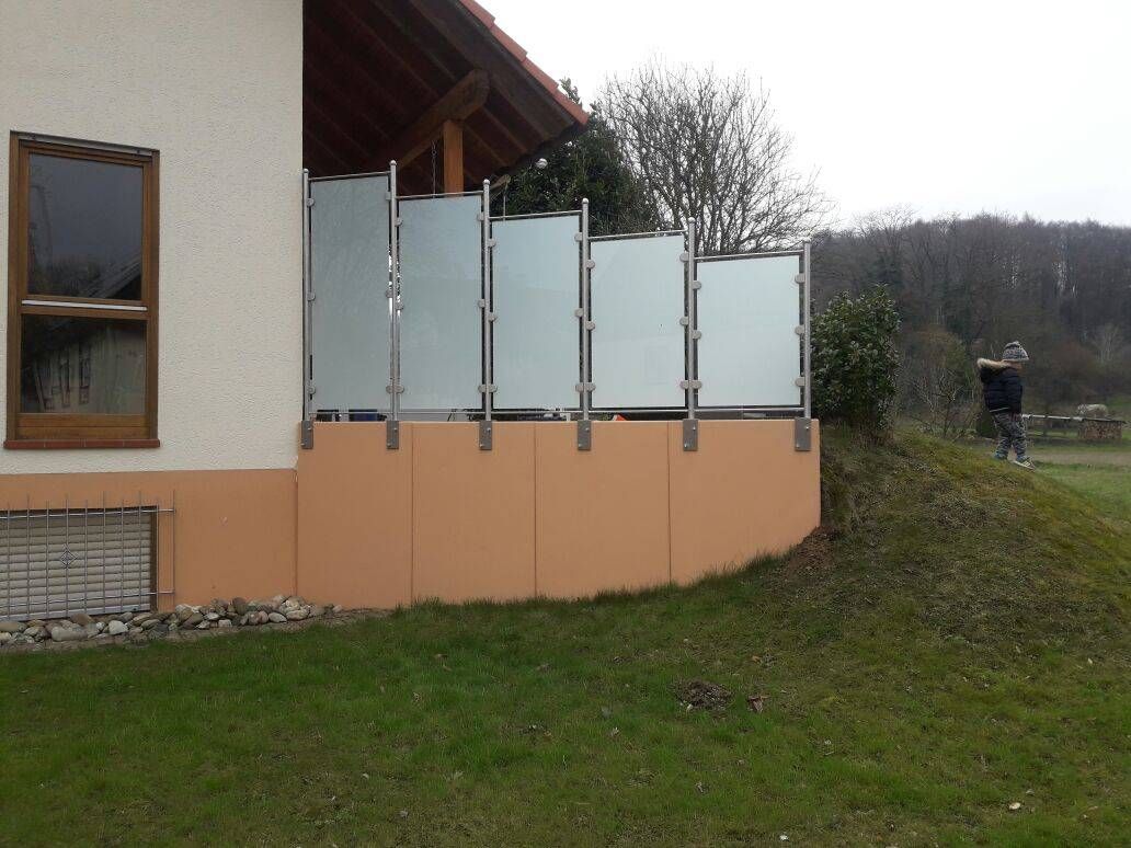 ein Haus mit einem Zaun und einem Fenster an der Seite.