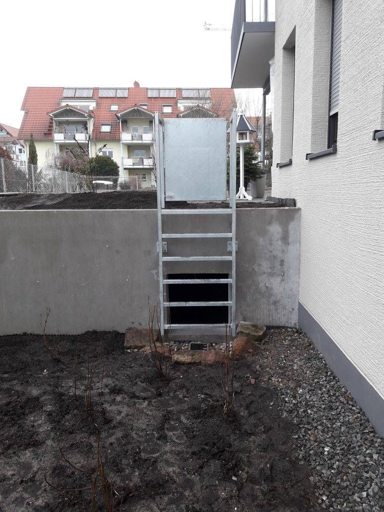 An der Seite eines Gebäudes ist eine Metallleiter angebracht.