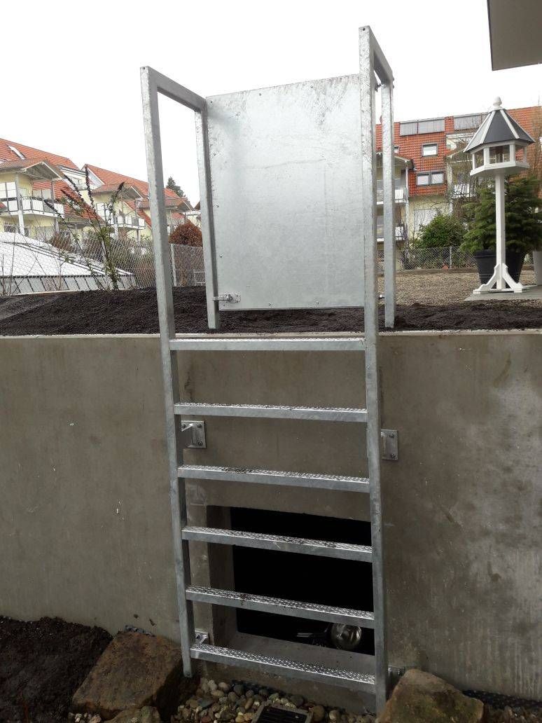 Eine Metallleiter ist an einer Betonwand befestigt.