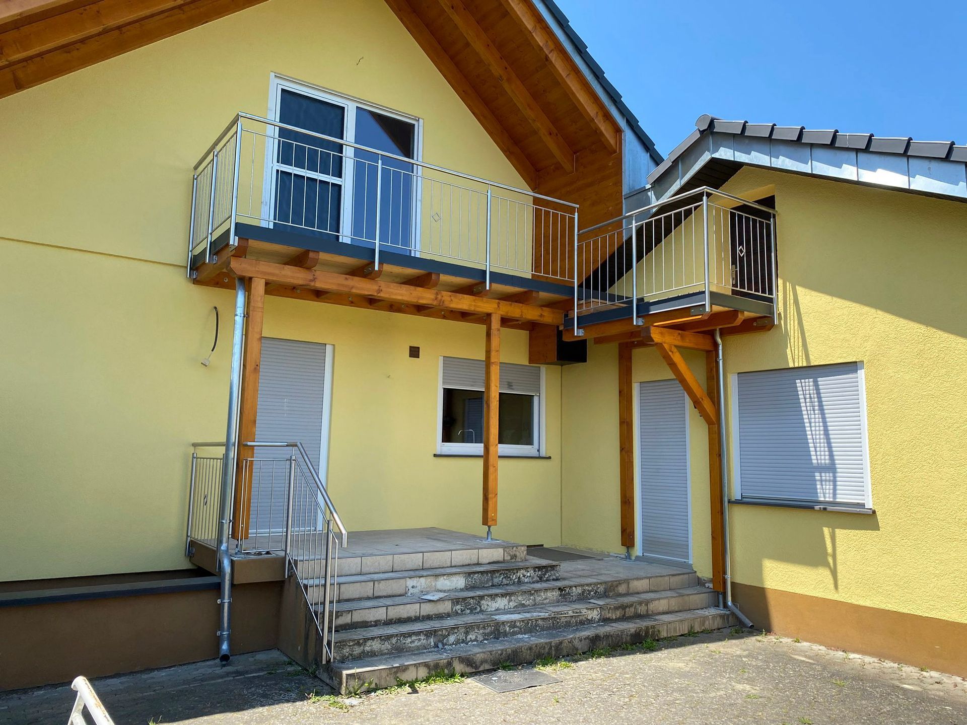 ein gelbes Haus mit Balkon und Treppe