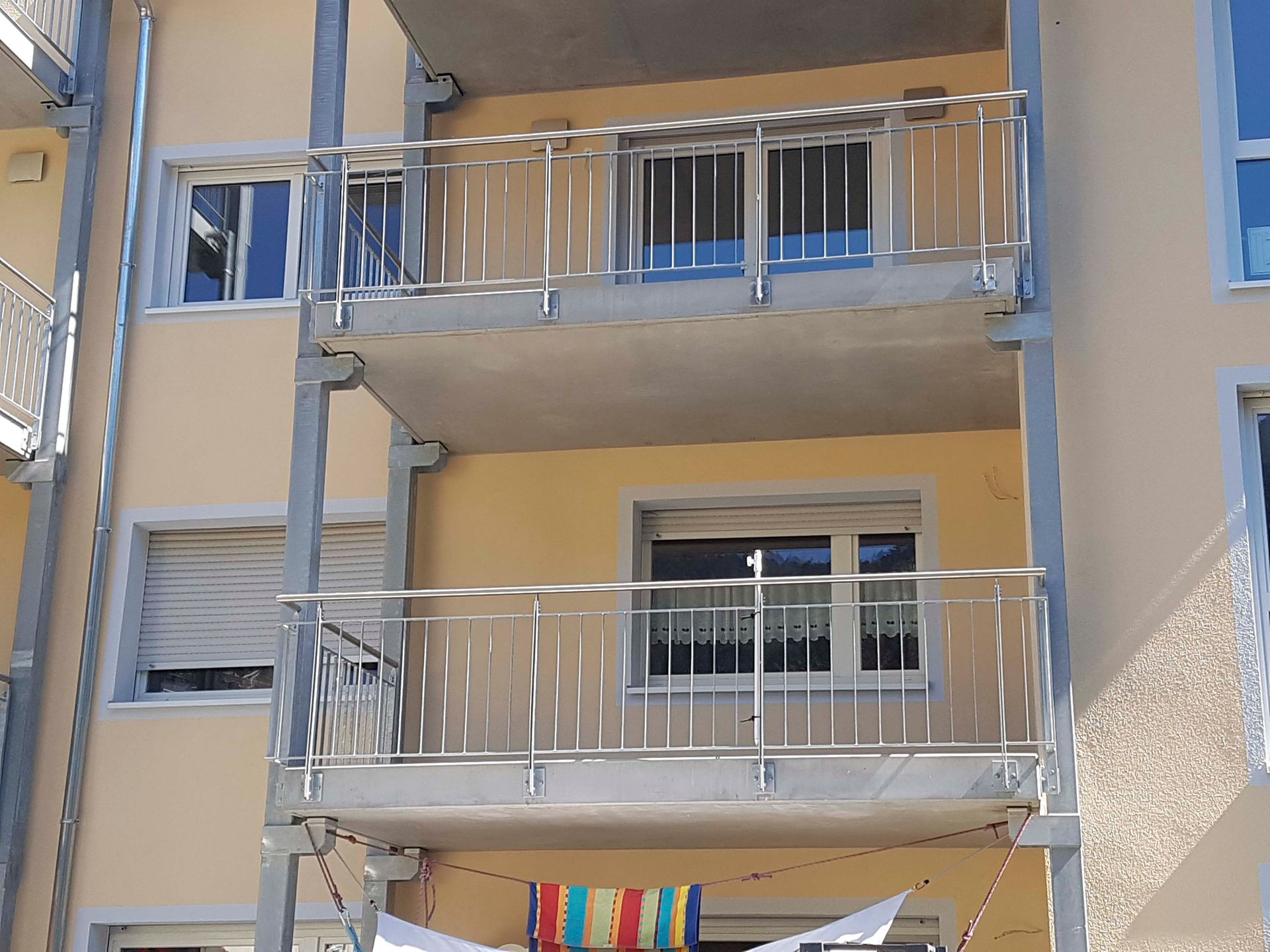 ein Balkon, an dem eine Regenbogenfahne hängt