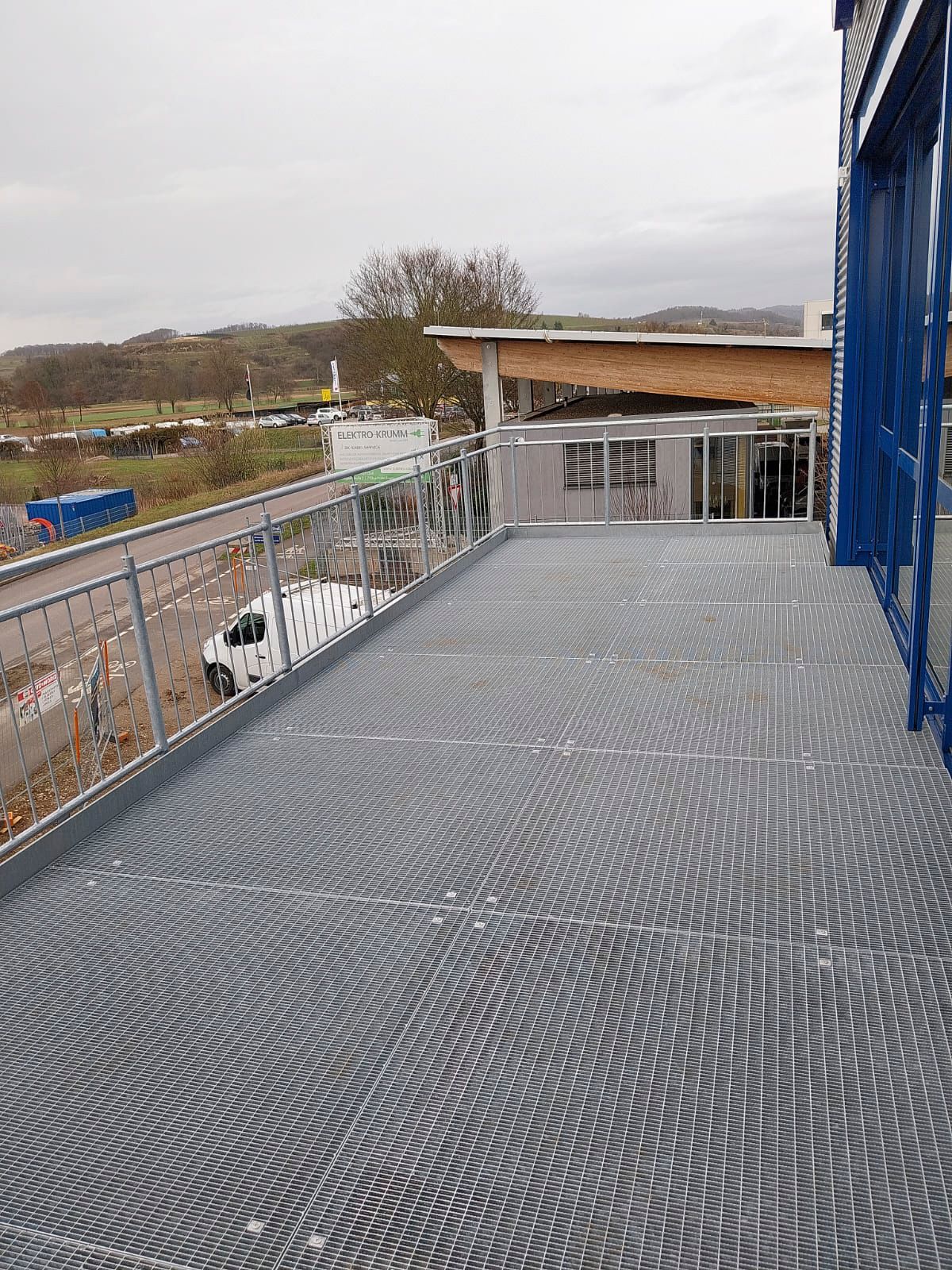 ein Metalldeck mit Treppen, die zu einem Gebäude hinaufführen.