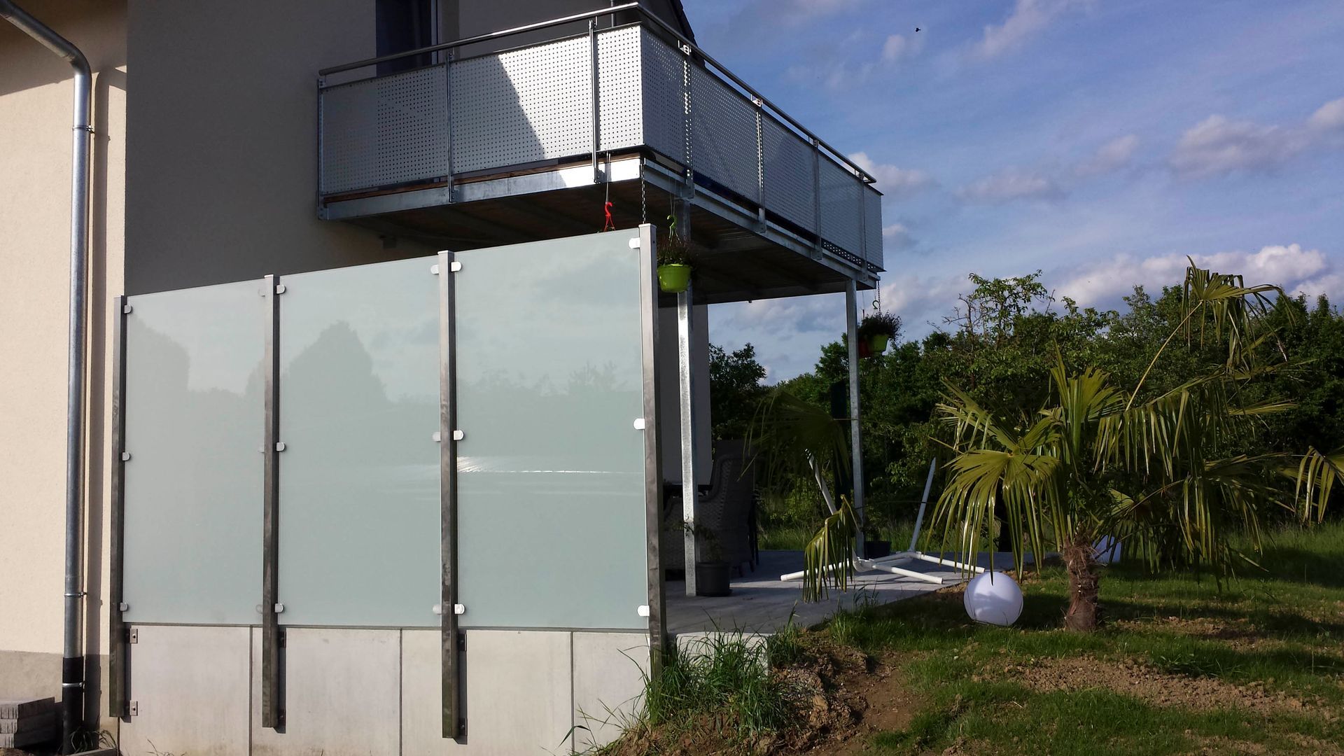 ein weißes Haus mit Balkon und Glaszaun