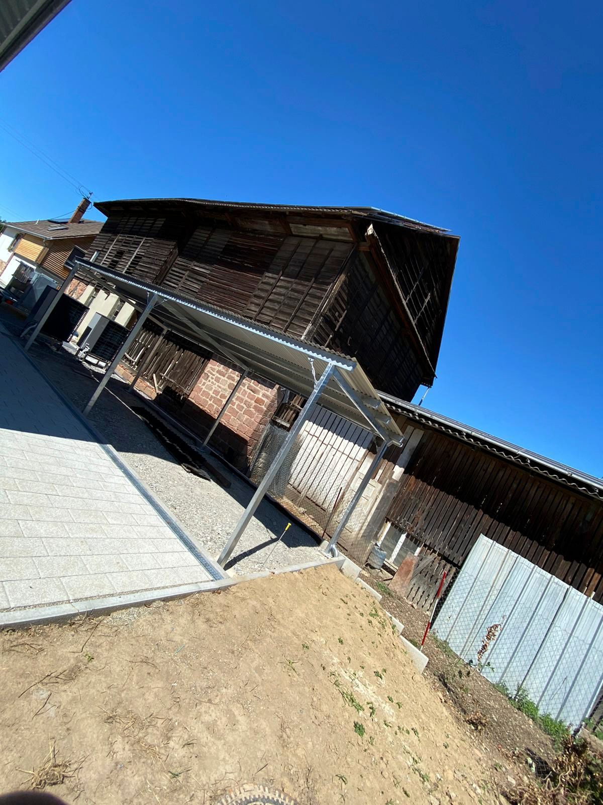 ein großes Holzgebäude mit einem überdachten Bereich davor.