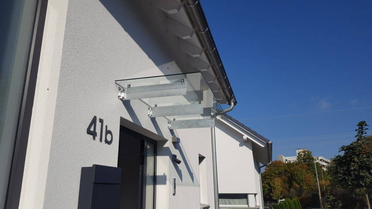 ein weißes Haus mit einem Glasdach und der Nummer 41b an der Seite