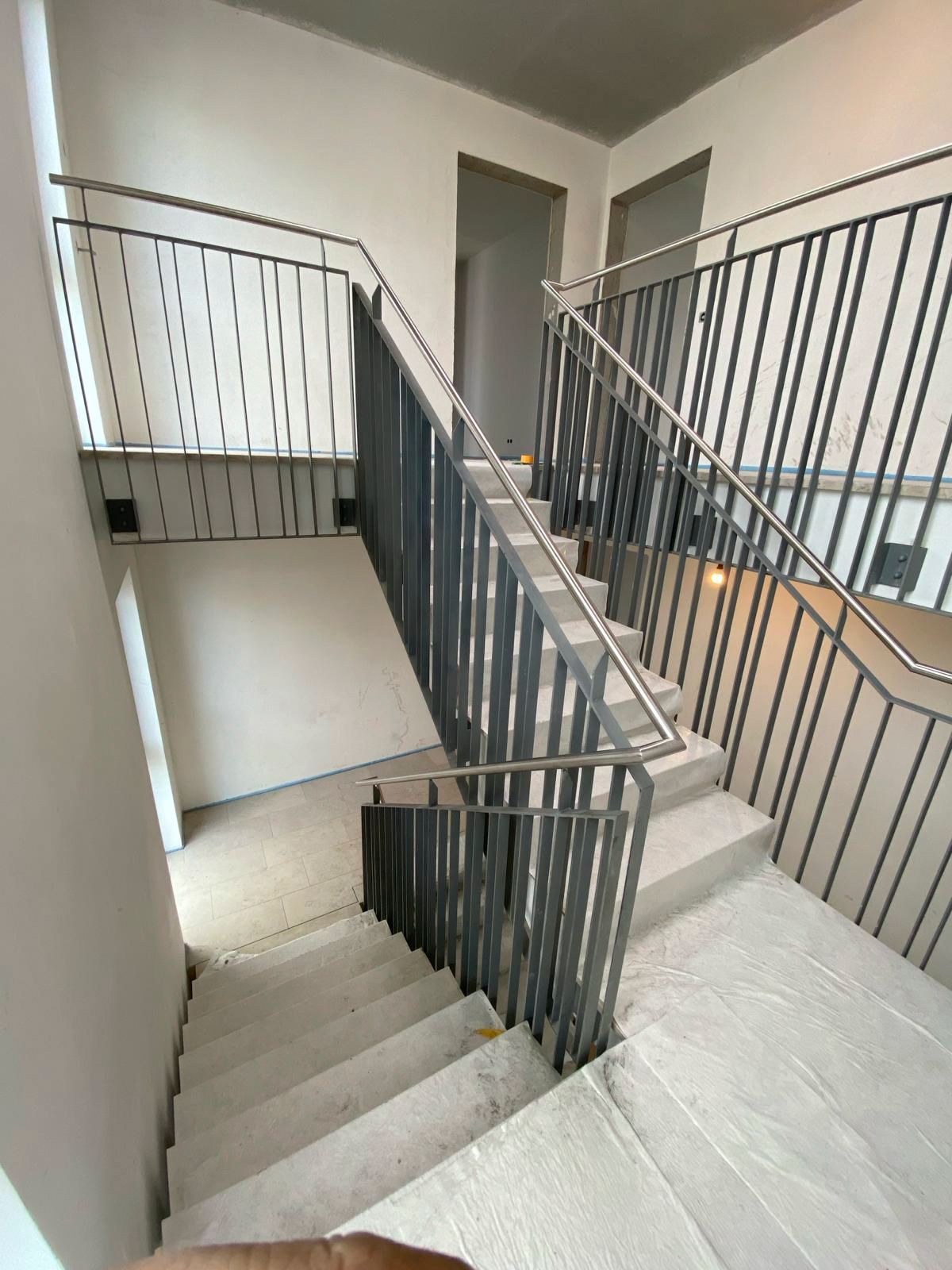 Eine Treppe mit einem Metallgeländer in einem Gebäude.