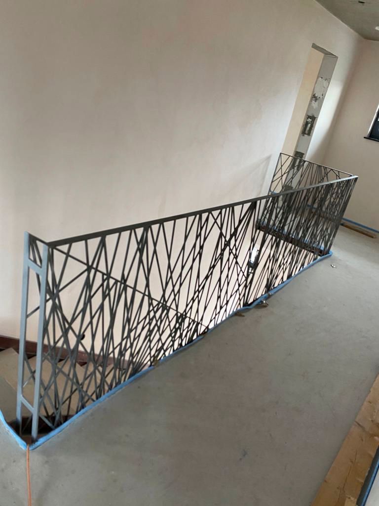 eine Treppe mit einem schmiedeeisernen Geländer in einem Raum.