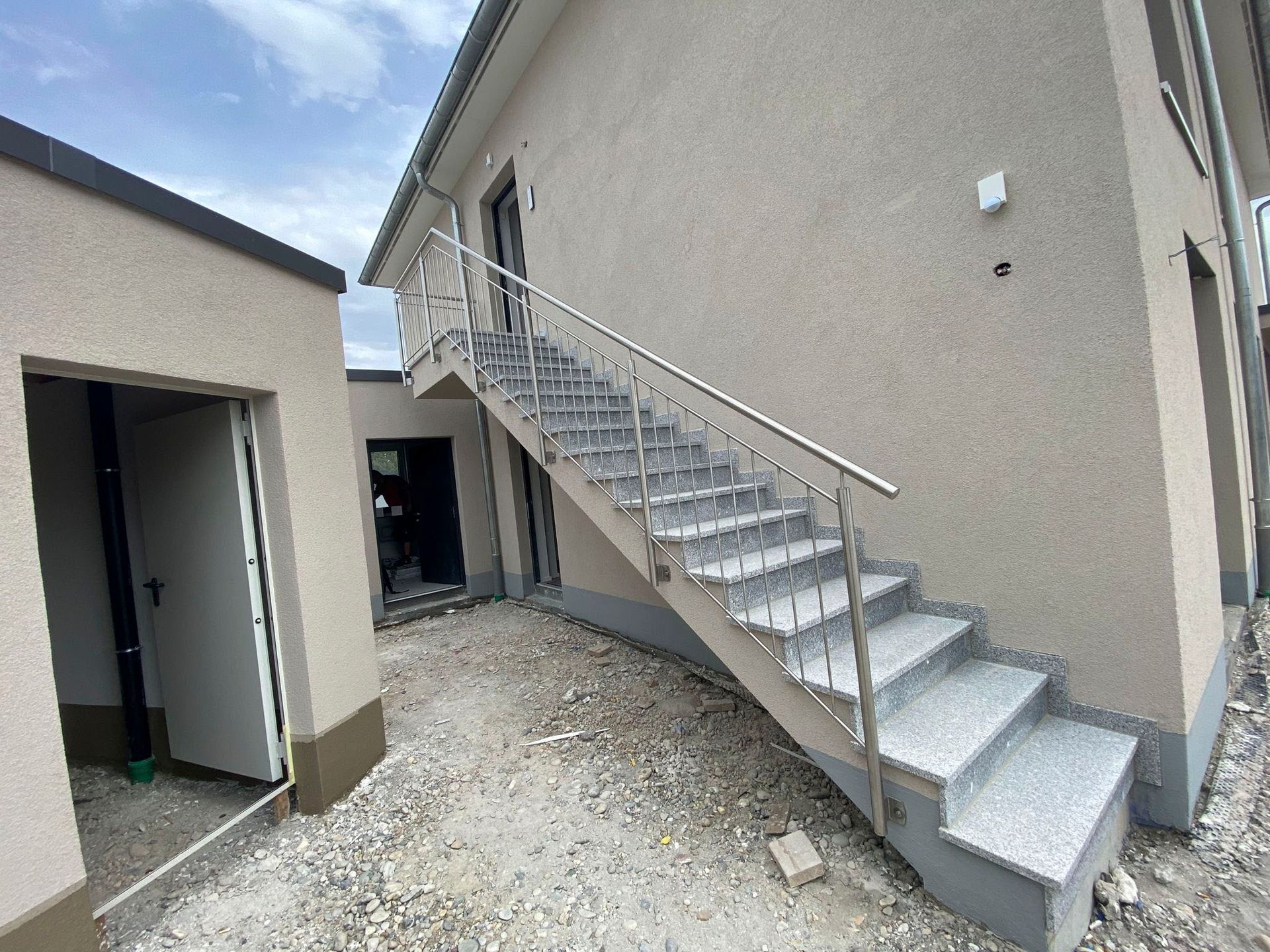 Eine Treppe, die zu einem Gebäude mit einem Geländer aus Edelstahl führt.