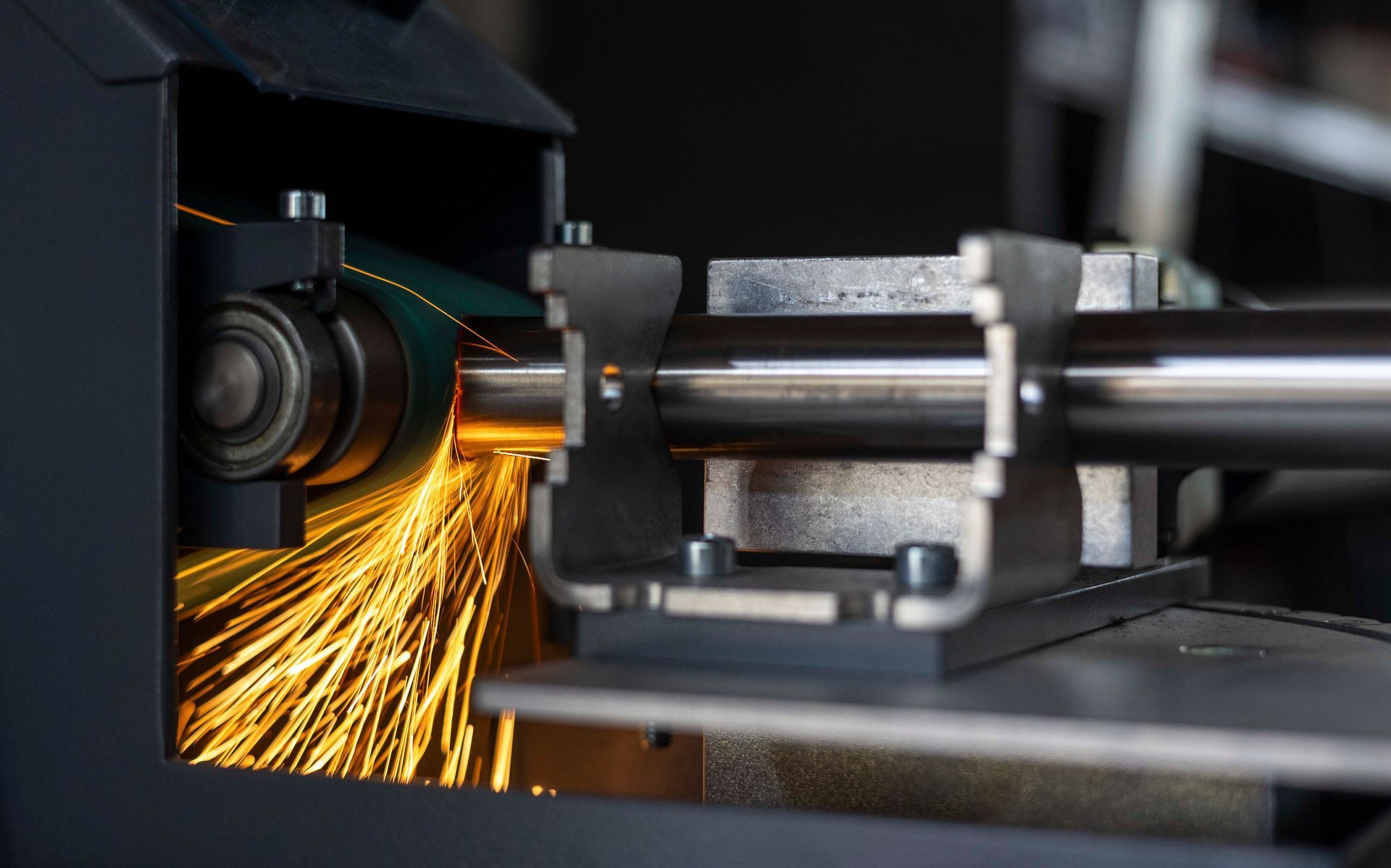 Eine Maschine schleift ein Stück Metall, aus dem Funken sprühen.