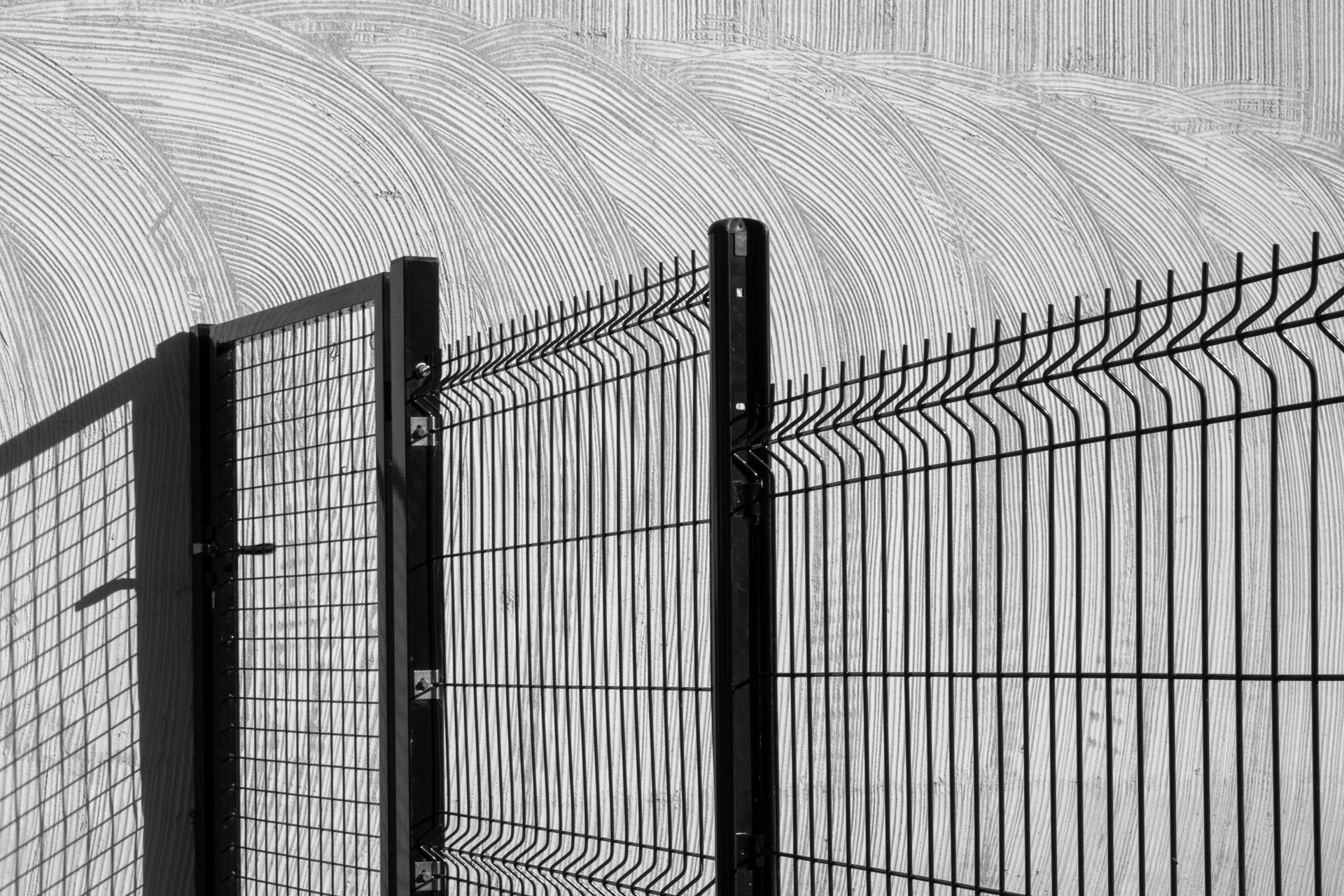 Clôture en métal noir avec un portillon d'accès.