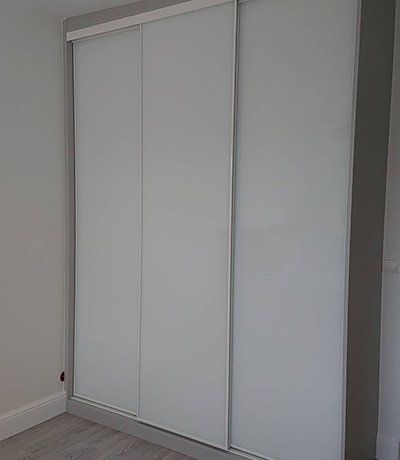 Installation dressing sous pente avec portes pliantes blanches et bois