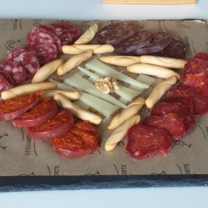 Surtido de embutidos y salchichas en rodajas dispuestas en una bandeja en forma circular.