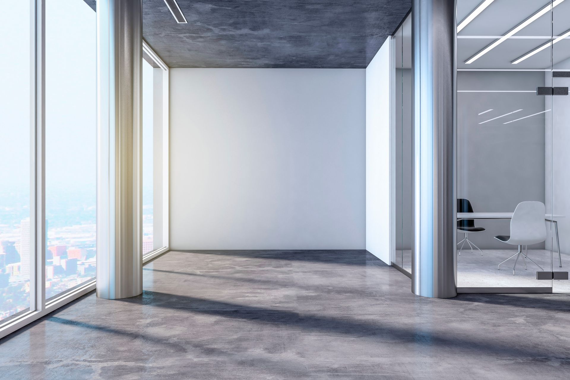 Una oficina vacía con muchas ventanas y piso de concreto.