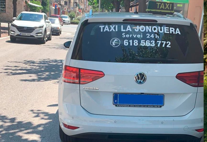 Un taxi blanco está estacionado al costado de la carretera.