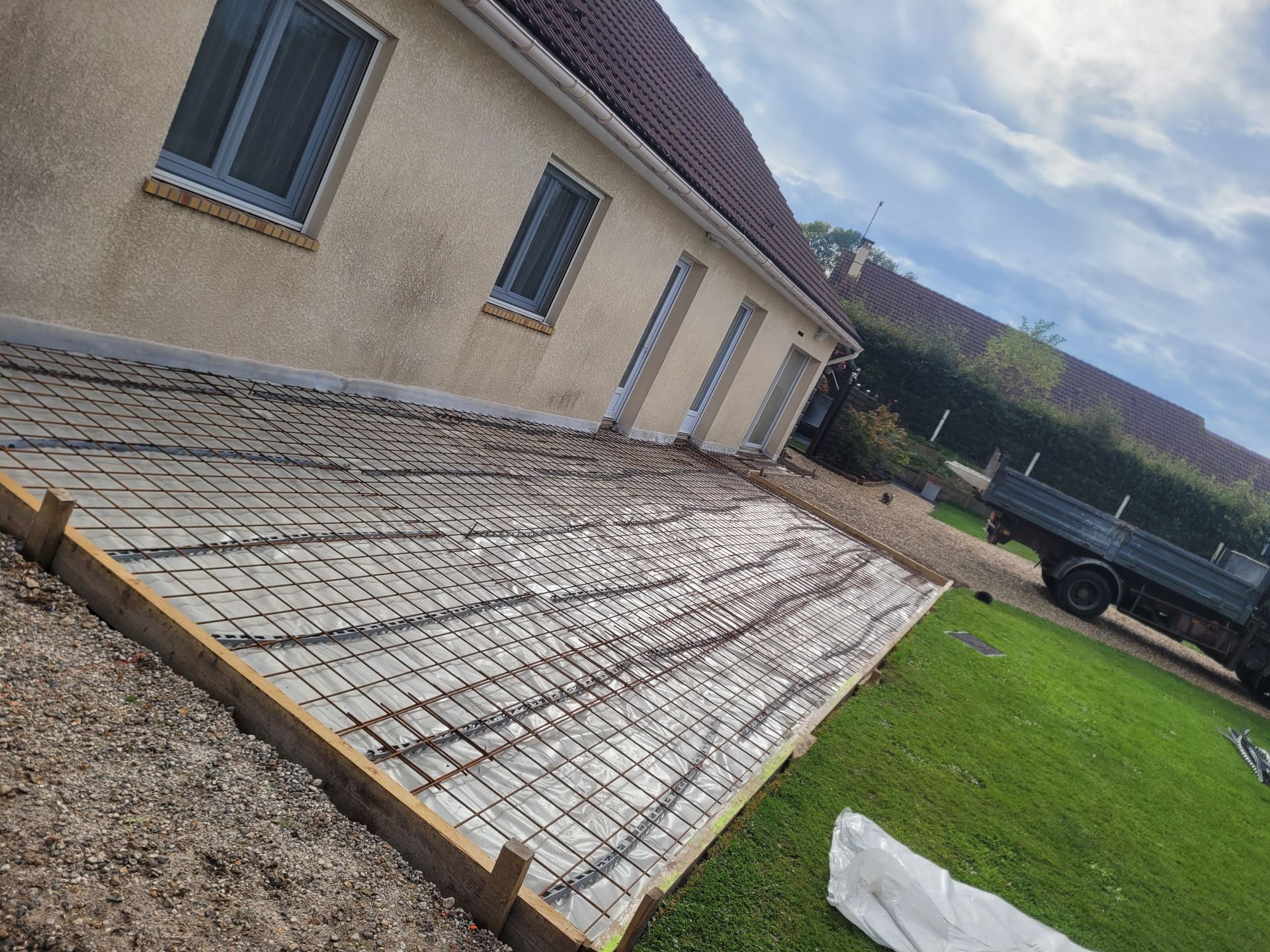 Travaux en cours pour la mise en place d'une terrasse devant un pavillon