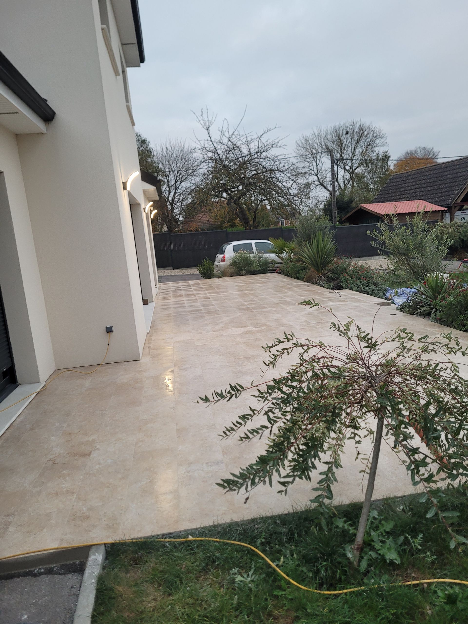 Vaste terrasse claire installée devant une maison individuelle