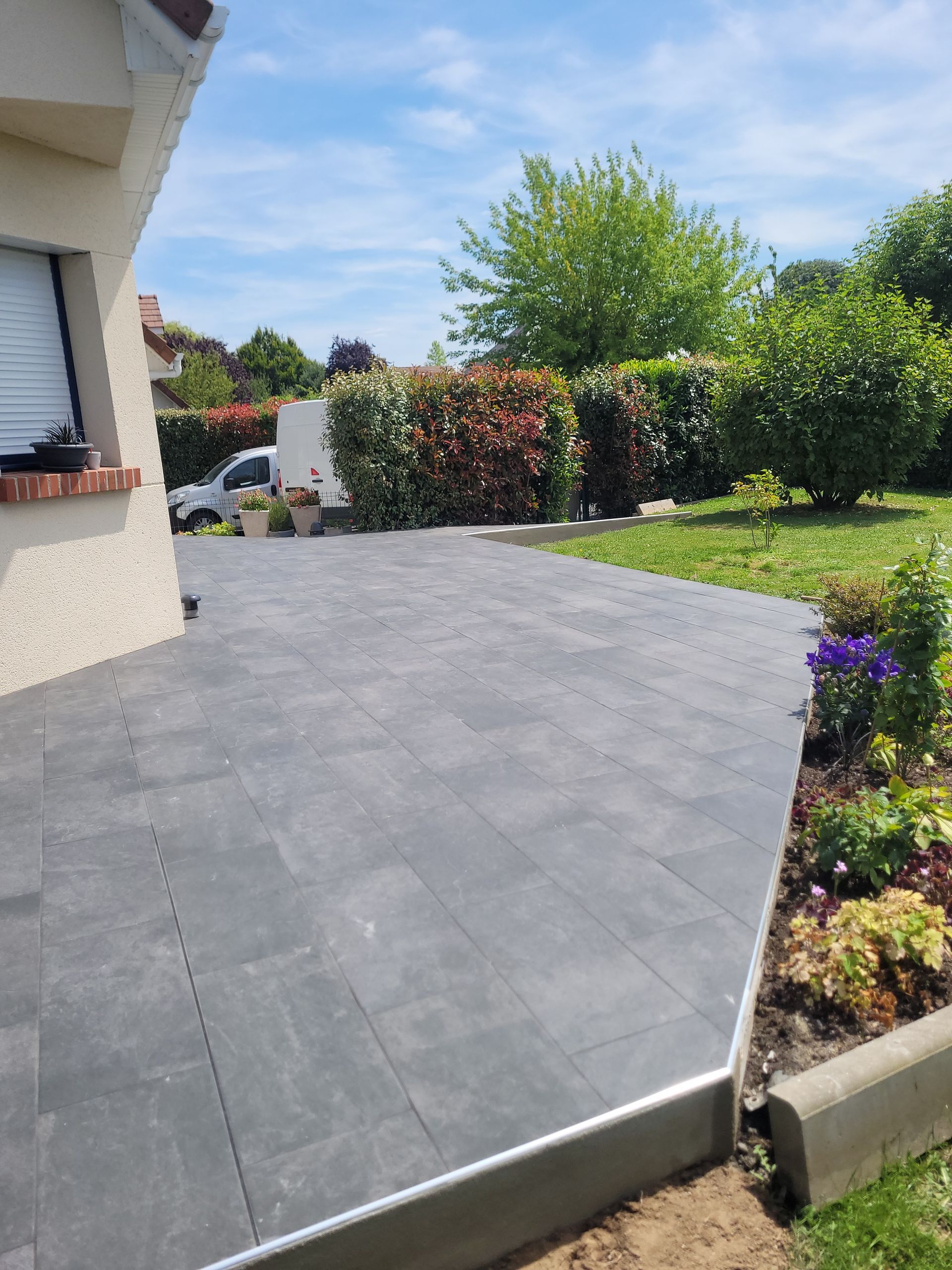 Dallage couleur béton pour une terrasse extérieure accolée à une maison individuelle