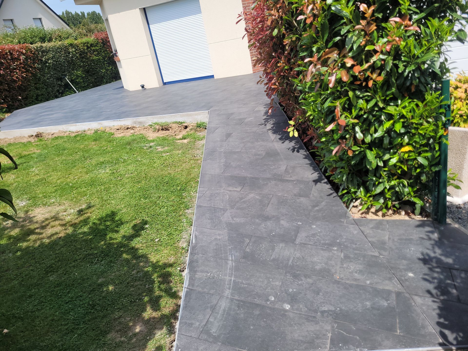 Terrasse dallée de couleur gris sombre permettant de dessiner un chemin d'accès en jardin