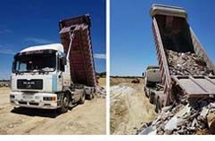 Camión volquete descargando arena en una obra en construcción, visto desde el frente y de lado.
