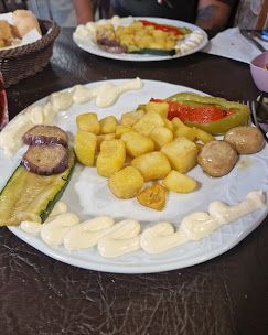 Un plato de comida con patatas y verduras en una mesa.