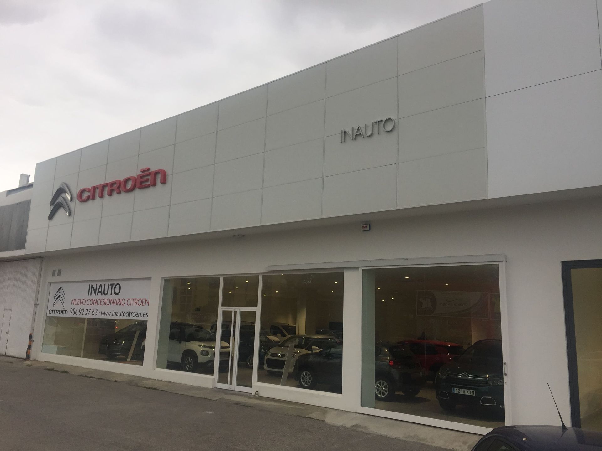 Concesionario de automóviles Citroën con edificio blanco, escaparates con coches y el logotipo de Citroën.