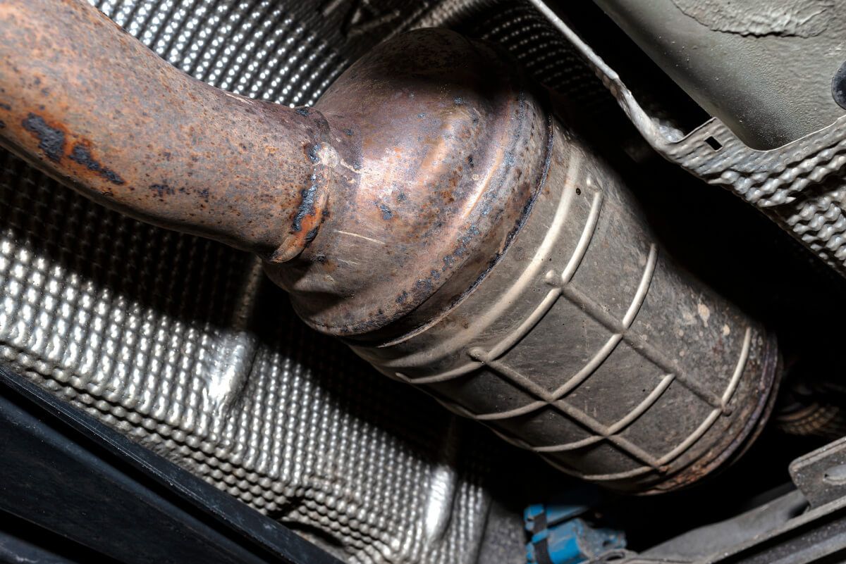 A close up of a catalytic converter on the underside of a car.