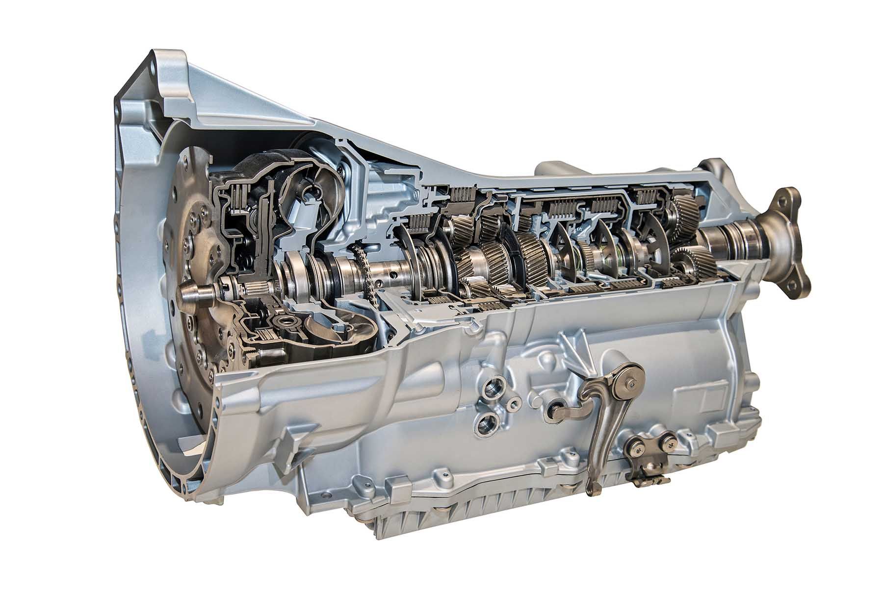 A close up of a cut in half automatic transmission on a white background.