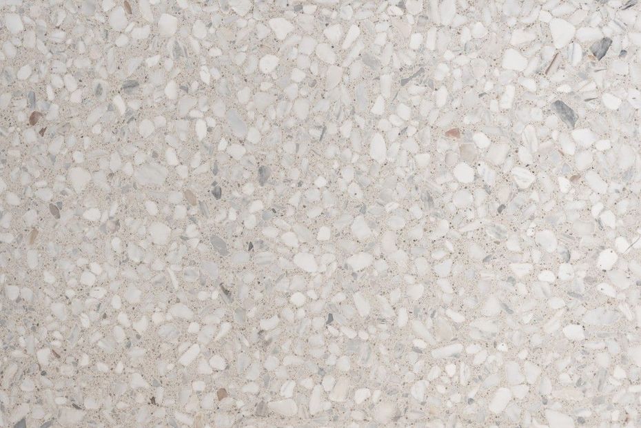Primer plano de una superficie texturizada moteada de color gris claro.