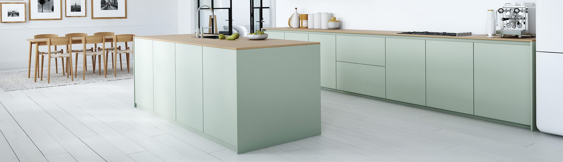 Moderni keittiö, jossa mintinvihreä saareke ja kaapistot, puiset työtasot ja valkoinen lattia.